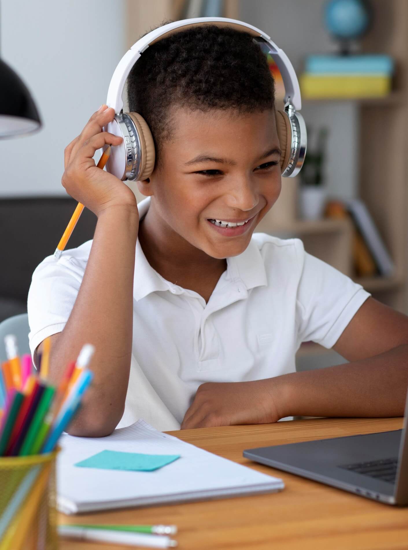 Criança estudando e ouvindo musica computador lapis na mao (1)